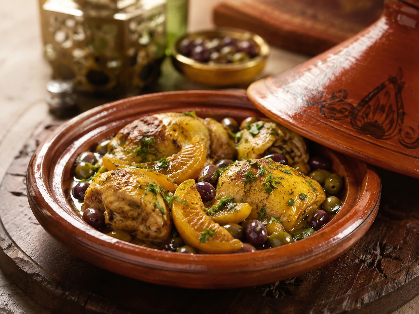 Photo réaliste d’un tajine de poulet aux citrons confits et olives de Marrakech.